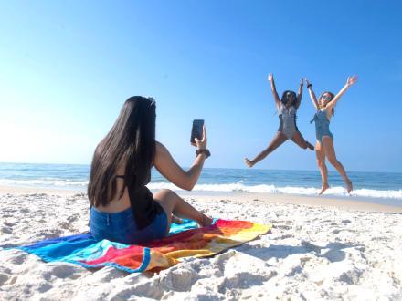 friends jumping and taking a photo on the beach in Gulf Shores