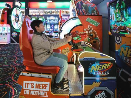 teen playing an arcade game at Arena Next Level Arcade at The Wharf