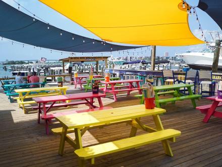 colorful picnic tables on the outdoor deck at Tiki family-friendly restaurant in Orange Beach