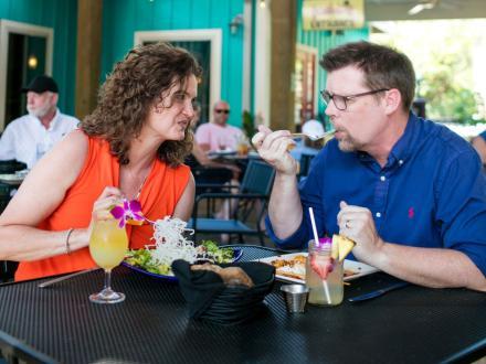 Couple enjoying fresh food and cocktails at Cosmo's restaurant in Orange Beach