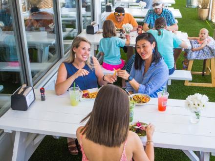 Friends dining on the deck at Picnic Beach restaurant in Gulf Shores