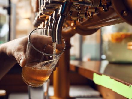 hand pouring a pint of beer from a tap