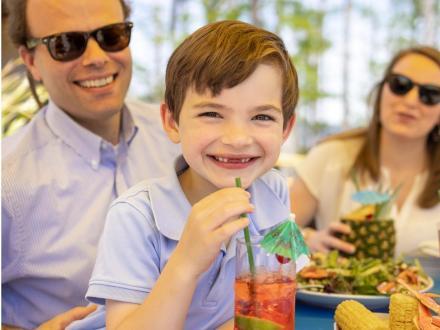Family with young boy dining at a table on the outdoor patio at GTs waterfront restaurant in Orange Beach