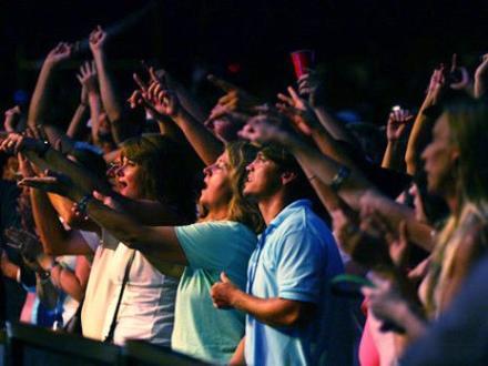 Crowd of people singing along to a live performance at The Wharf Amphitheater in Orange Beach