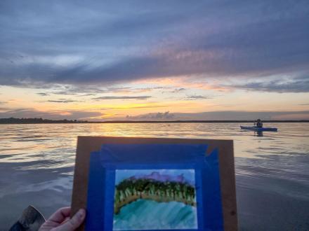 Kayaker painting a watercolor scene while on a kayaking excursion in Orange Beach