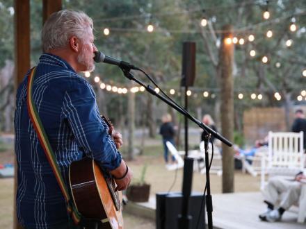 Musician performing on the stage at Woodside outdoor restaurant in Gulf State Park