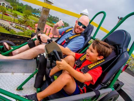 Dad and son racing a go-kart at The Track, go-kart track in Gulf Shores