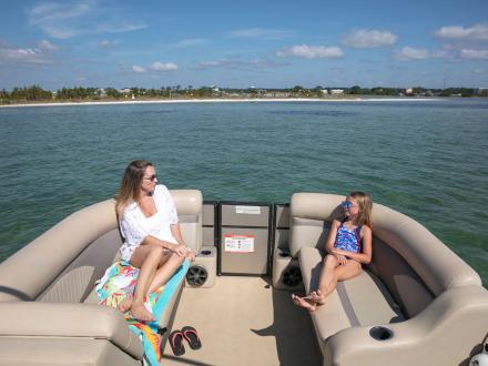 Mom and young daughter relaxing on a pontoon boat while cruising through the waters of Orange Beach