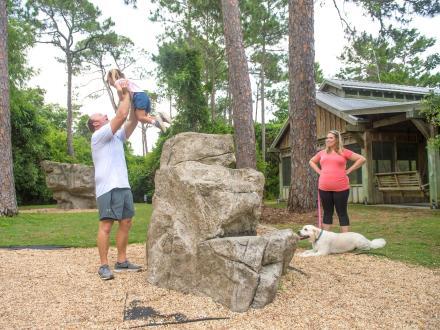 Family with young girl playing at Bouldering Park inside Gulf State Park