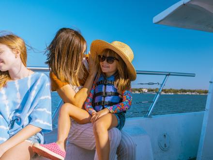 Girl sitting in her mom's lap on a dolphin cruise in Orange Beach