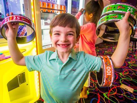 Little boy holding tickets won at the arcade at The Track Family Fun Park