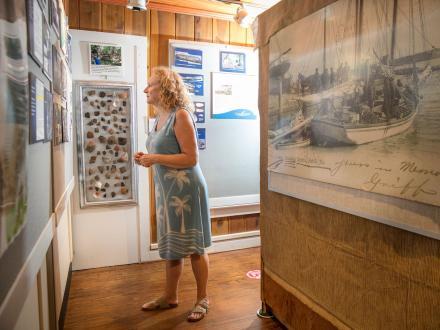 Woman admiring the exhibits inside the Gulf Shores Museum