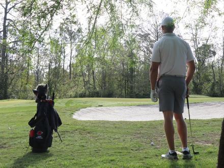 Golfer standing under the shade of trees along Craft Farms golf course