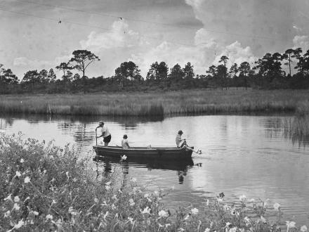 Old photo of people canoeing in the waterways of Gulf Shores