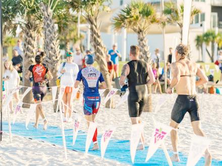 racers running on the beach during the Brett/Robinson Alabama Coastal Triathlon in Gulf Shores