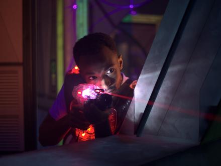 Man pointing a laser gun during a round of laser tag