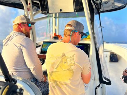 Two men driving a boat in the Gulf in Orange Beach