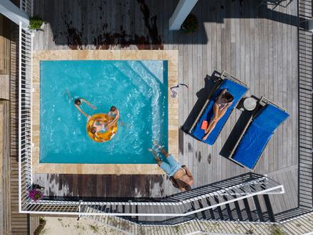 aerial shot of family playing in private pool at a beach house in Gulf Shores