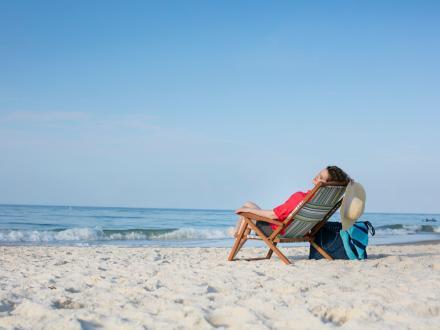 Woman relaxing in a beach chair on the shore of Orange Beach