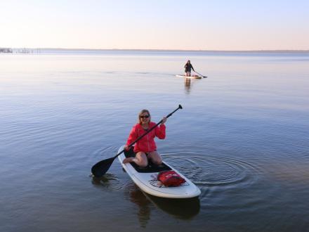 women paddle boarding along the back bays in Orange Beach