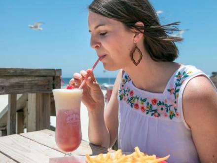 Woman drinking a frozen cocktail at Pink Pony Pub beachfront restaurant