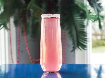 Bright pink mimosa with edible glitter at High Tide Daiquiris & Mimosas waterfront bar