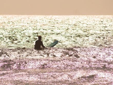 silhouette of a surfer sitting on a board in the Gulf in Orange Beach