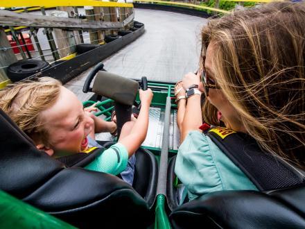 mom and daughter racing a go-kart at The Track Family Fun Park attraction in Gulf Shores