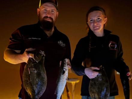 anglers holding fish caught while night fishing in Orange Beach