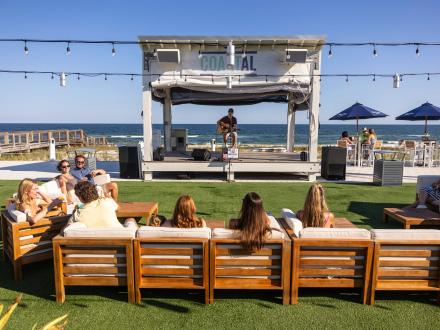 People enjoying live music by the beach at Coastal Orange Beach waterfront restaurant