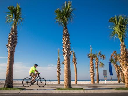 snowbird biking along the beach at Gulf Place in Gulf Shores
