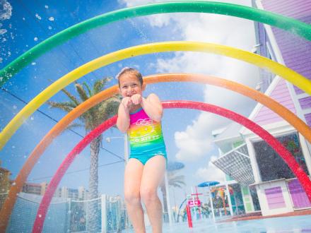 Young girl playing in the splash pad at Surf Style beach store in Orange Beach