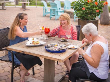 A group of women dining on the patio at Cobalt waterfront restaurant in Orange Beach