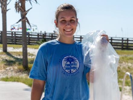 volunteer picking up litter on the beach during the Alabama coastal cleanup