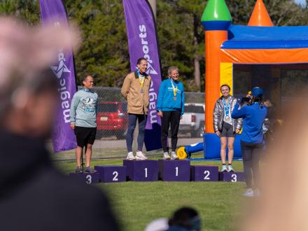 Winning racers standing on the podium during the awards ceremony at the Coastal Half Marathon in Orange Beach
