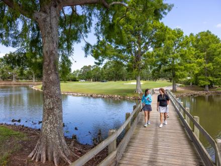 Women walking along a boardwalk in Craft Farms Golf Resort in Gulf Shores