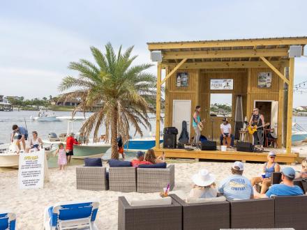 People listening to live music on the beach at Flora-Bama Yacht Club waterfront restaurant