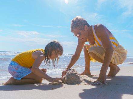 grandma and grandkid playing in the sand in Gulf Shores