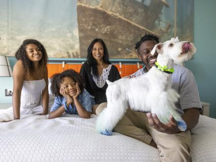 A family enjoying their hotel on Alabama's Beaches that is pet-friendly"]