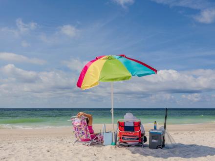 couple sitting on the beach under an umbrella in Gulf Shores