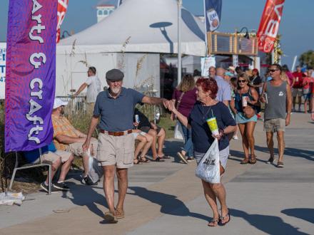 Couple strolling the beachfront grounds of the Annual National Shrimp Festival in Gulf Shores