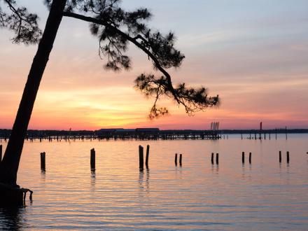 sunset over the bay at orange beach waterfront park
