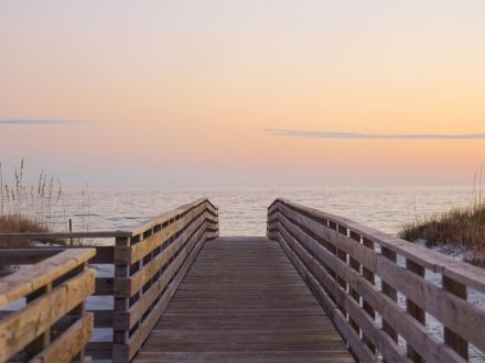 boardwalk leading the beach at sunset