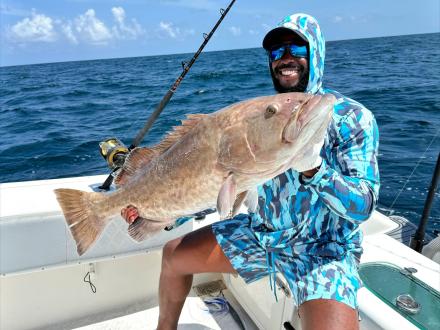 Man holding a gag grouper caught on a charter fishing trip in Orange Beach
