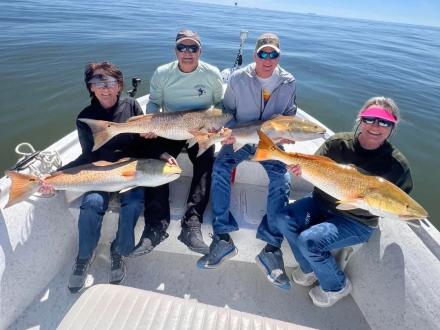 anglers holding redfish caught on a charter in Orange Beach