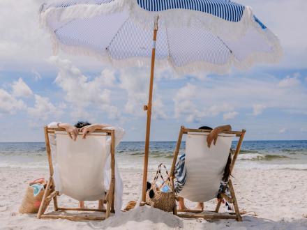 Girlfriends relaxing on the beach under an umbrella in Orange Beach