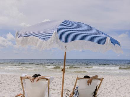 Lady enjoying her time on Alabama's Beaches under her umbrella and beach chair
