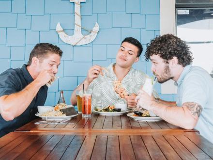 Guys dining on the deck at Beach House Kitchen & Cocktails restaurant in Gulf Shores