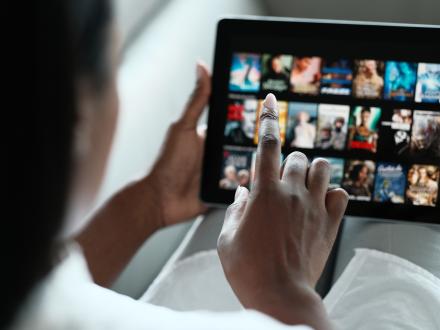 Hands scrolling through movies on a iPad