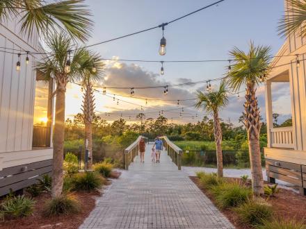 Family walking along a scenic trail leading to Gulf State Park from Beach Village Resort in Orange Beach